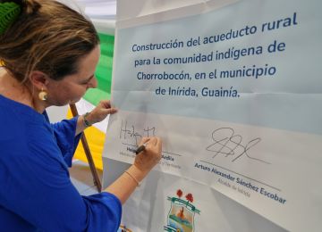 FOTOGRAFÍA, FIRMA DE LA MINISTRA HELGA RIVAS PARA EL INICIO DE ESTUDIOS, DISEÑOS PARA LA OBRA DE UN PARQUE RECREODEPORTIVO EN EL BARRIO ZONA INDÍGENA