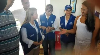 Con gorra y chaleco del ejercito azul Ministra Noguera atiende a beneficiarios de viviendas gratis en Sincelejo